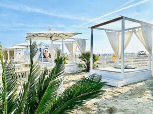 un pabellón en la playa con una sombrilla en Appartamento Lido degli Estensi a 100 mt dal mare e dal centro, en Lido degli Estensi