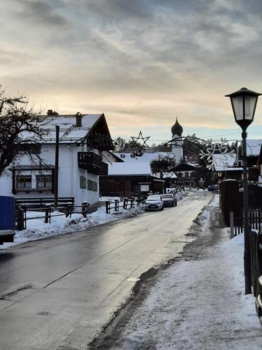 a snow covered street with buildings and a street light at Zum Franziskaner in Grainau