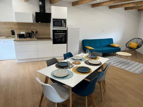 a kitchen with a white table and chairs and a kitchen with at Maison charmante pour 4/6 pers in Brassac-les-Mines