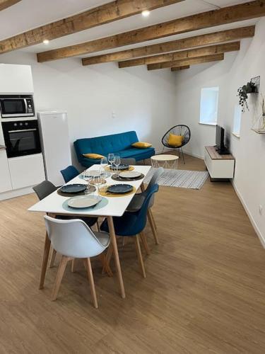 a living room with a table with chairs and a kitchen at Maison charmante pour 4/6 pers in Brassac-les-Mines