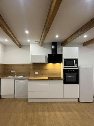 a large kitchen with white cabinets and appliances at Maison charmante pour 4/6 pers in Brassac-les-Mines