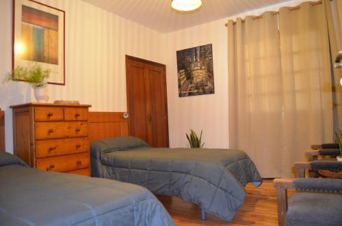 um quarto com duas camas e uma cómoda em Casa Aurora em Teo