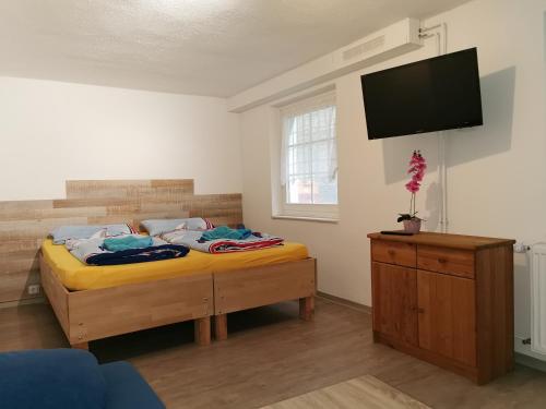 um quarto com uma cama e uma televisão de ecrã plano em Pension Kerstin em Warnemünde