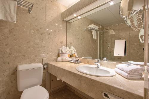 a bathroom with a sink and a toilet and a mirror at Mercure Paris Velizy in Vélizy-Villacoublay