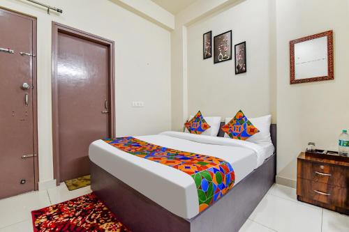 - une chambre avec un lit et une porte en bois dans l'établissement FabHotel Moon Light Palace, à Jaipur