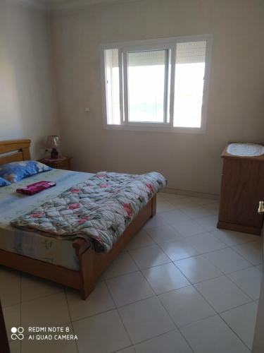 a bedroom with a bed and a window at Appartement agadir centre in Agadir