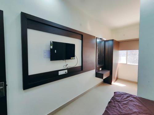 Hotel Heritage Palace في بهوي: غرفة نوم مع تلفزيون بشاشة مسطحة على الحائط