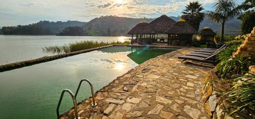 a swimming pool next to a large body of water at Birdnest Resort in Kabale