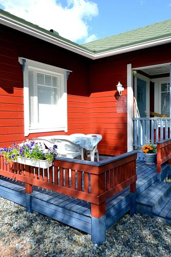 a red house with a porch with flowers on it at Talo Ylläs in Äkäslompolo