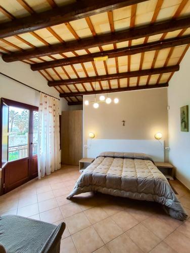 a bedroom with a large bed with a wooden ceiling at Casolare Nelle Saline in Torre Nubia