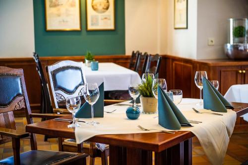 a table in a restaurant with wine glasses on it at Auehof Hotel & Restaurant in Garrel