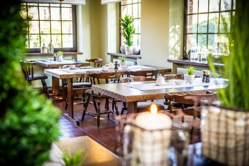 a restaurant with tables and chairs and windows at Auehof Hotel & Restaurant in Garrel
