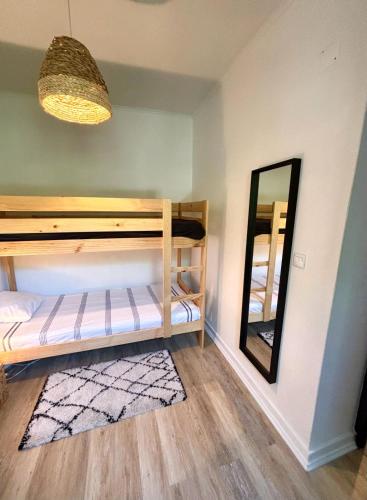 a bedroom with bunk beds and a mirror at Pine & Apple Sintra Beach House in Colares
