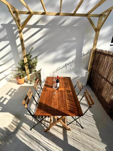 a wooden table and chairs on a patio at Pine & Apple Beach House in Colares