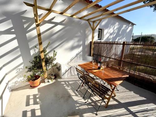 a wooden table and chairs on a patio at Pine & Apple Beach House in Colares