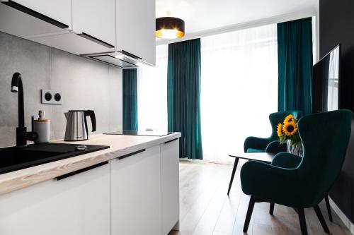 a kitchen with white cabinets and a table and chairs at HOUSEHOST Apartments: Miodowa 42/12b Street in Krakow