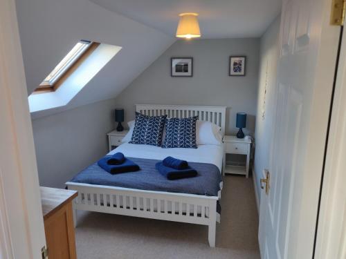 um quarto com uma cama com almofadas azuis em Weavers Cottage em Haverfordwest
