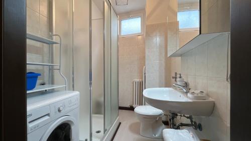 uma casa de banho com uma máquina de lavar roupa e um lavatório em La casa di Ange - Affitti Brevi Italia em Lecco