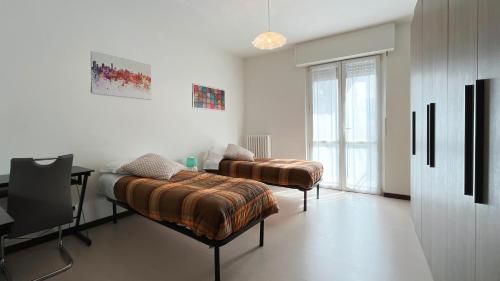 um quarto com duas camas e uma secretária em La casa di Ange - Affitti Brevi Italia em Lecco