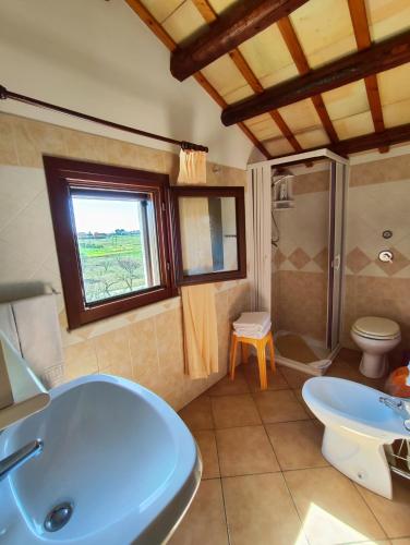 a bathroom with a tub and a toilet and a sink at Casolare Nelle Saline in Torre Nubia
