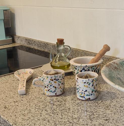 a kitchen counter with three cups and a bottle at ENDAGORA in Níjar