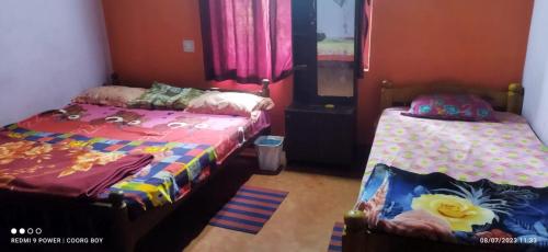 Padakalu的住宿－Harakoppa Hills，一间卧室设有两张床,窗户配有粉红色的窗帘