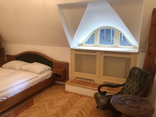 a bedroom with a bed and a window and a chair at Herrnhof Appartement Adele in Neunkirchen