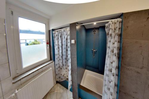 La salle de bains est pourvue d'une baignoire et d'une fenêtre. dans l'établissement Twój Hostel Bytom, à Bytom