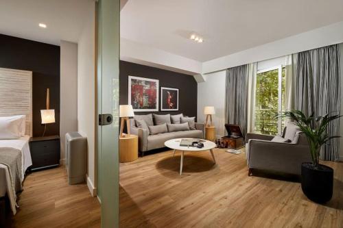 ein Hotelzimmer mit einem Bett und einem Wohnzimmer in der Unterkunft Viola Comfort Suite in Athen