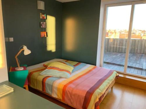 Schlafzimmer mit einem Bett mit einem Tisch und einem Fenster in der Unterkunft Rooftop terrasse 360° hypercentre in Toulouse
