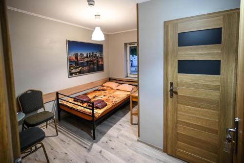 a small bedroom with a bed and a door at Hostel CENTRUM in Radom