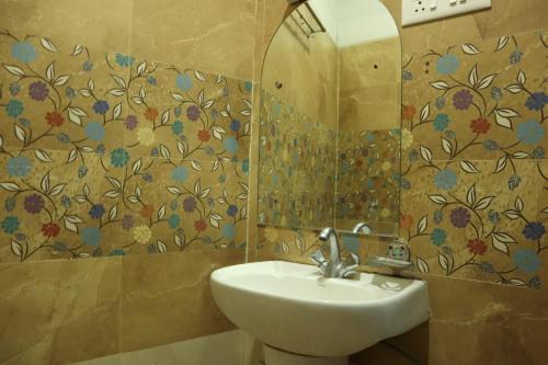 een badkamer met een wastafel en een spiegel bij Radhe Radhe Guest House in Dehradun