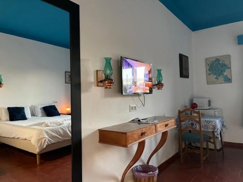 a bedroom with a bed and a desk with a tv at Casa Santo António in São Brás de Alportel