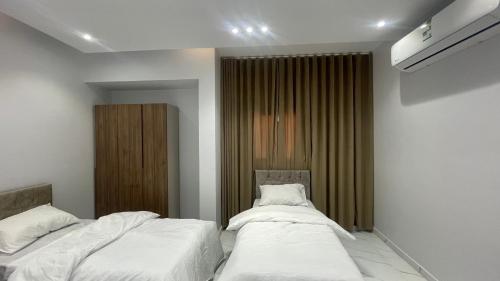 sypialnia z dwoma łóżkami i oknem w obiekcie شقة غرفتين وصاله w mieście Al ‘Uqūl
