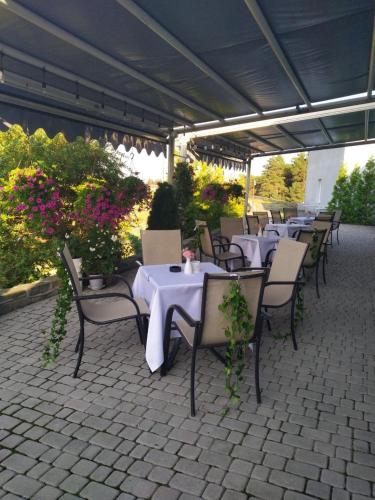 an outdoor patio with tables and chairs and flowers at Hotel Forma in Piła