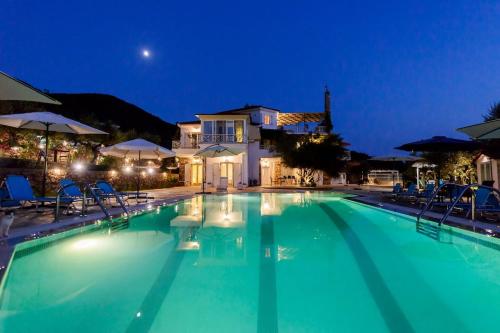 a swimming pool at night with a villa at Villa Needa's - Eros Loft with Infinity Pool in Kalamata