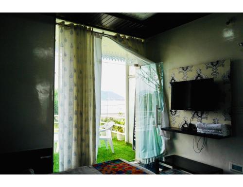 Zimmer mit einem TV und einem Fenster mit Aussicht in der Unterkunft Hotel Everest International,Udaipur in Udaipur
