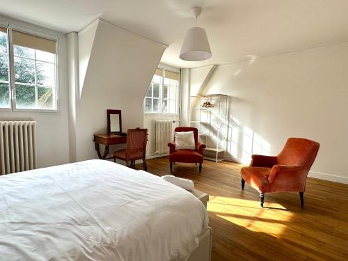 1 Schlafzimmer mit einem Bett und 2 Stühlen in der Unterkunft La Meslaysienne - Comfortable house, swimming pool in Meslay-le-Vidame