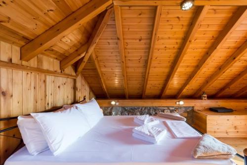 un lit dans une chambre avec un plafond en bois dans l'établissement Villa Needa's - Home Love Retreat by the Pool, à Kalamata