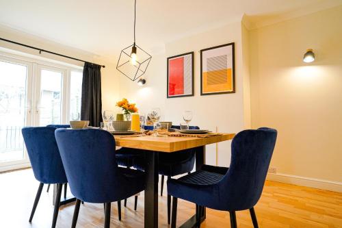 a dining room with a table and blue chairs at Southampton 3 Bedroom Luxury House in Southampton