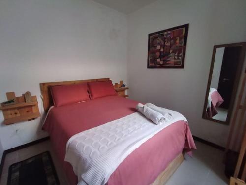 a bedroom with a bed with red and white sheets at Wavecrest in Horta