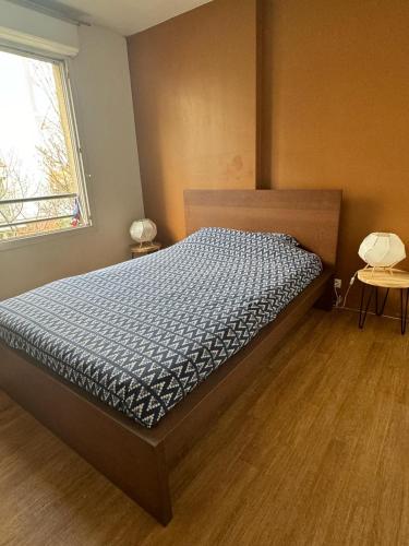 une chambre avec un lit dans une pièce avec une fenêtre dans l'établissement Le cocon du stade de France, à Saint-Denis