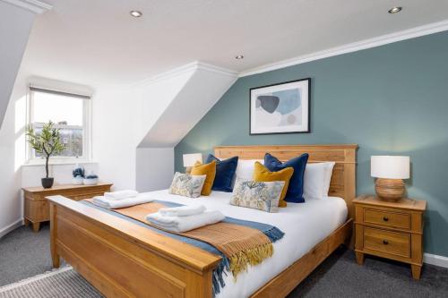 斯特靈的住宿－The Stirling Townhouse，一间卧室配有一张带蓝色墙壁的大床