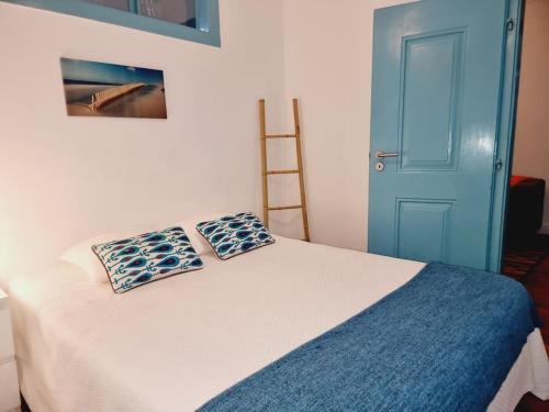 a bedroom with a bed with two pillows on it at Casa Azul by Ericeira Property in Ericeira