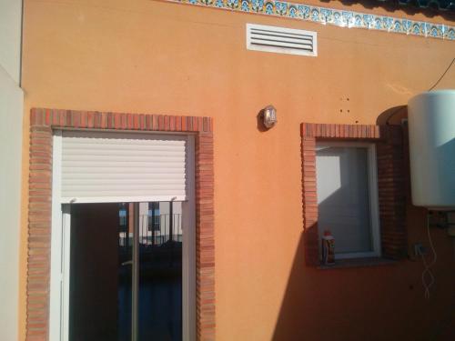 an orange building with a window and a door at Miramar in Almazora