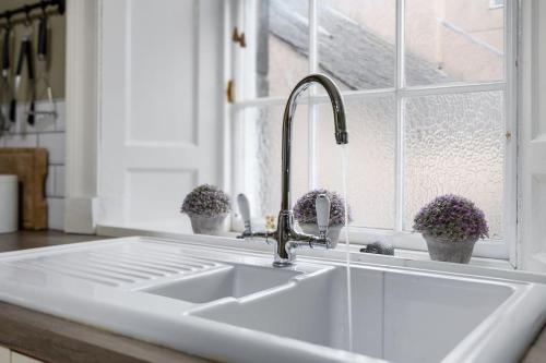 a white kitchen with a sink and a window at The Stirling Townhouse in Stirling