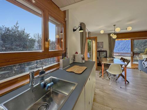 a kitchen with a sink and a table in a room at Magic view near slopes and termal bath - Swiss Alps in Ovronnaz