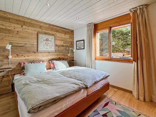 a bedroom with a bed with a wooden wall at Magic view near slopes and termal bath - Swiss Alps in Ovronnaz