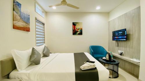 um quarto com uma cama e uma cadeira azul em Hotel Rex em Indore
