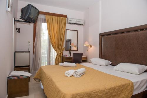 a hotel room with two beds with towels on them at Verdelis Inn in Ancient Epidavros